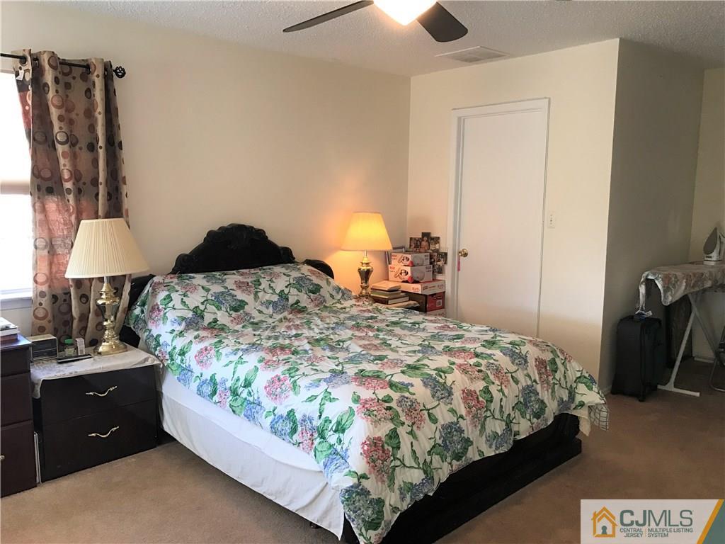 82 Orion Road, Unit 82 Piscataway, NJ 08854 - Photo 11 of 13 a bedroom with a bed and a lamp on dresser