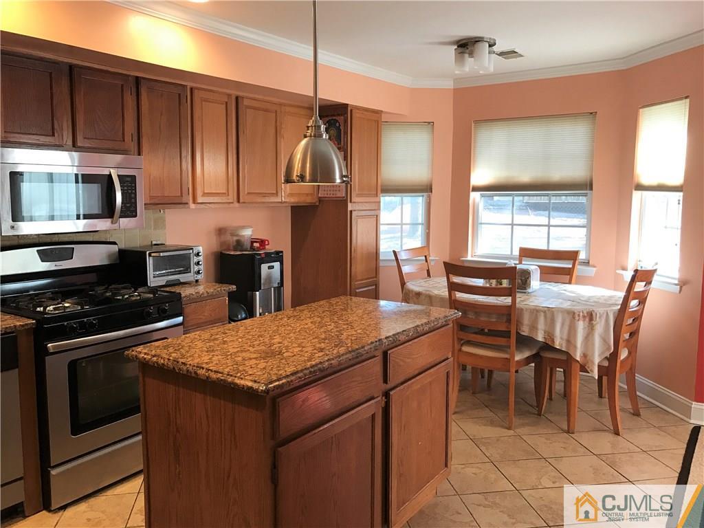 82 Orion Road, Unit 82 Piscataway, NJ 08854 - Photo 4 of 13 a kitchen with stainless steel appliances granite countertop a stove top oven a sink a dining table and chairs with wooden floor