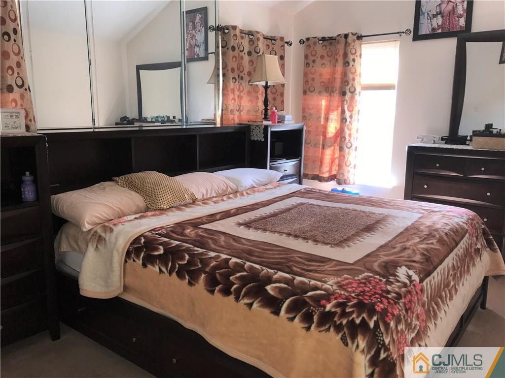 82 Orion Road, Unit 82 Piscataway, NJ 08854 - Photo 8 of 13 a bedroom with a bed and dresser with mirror