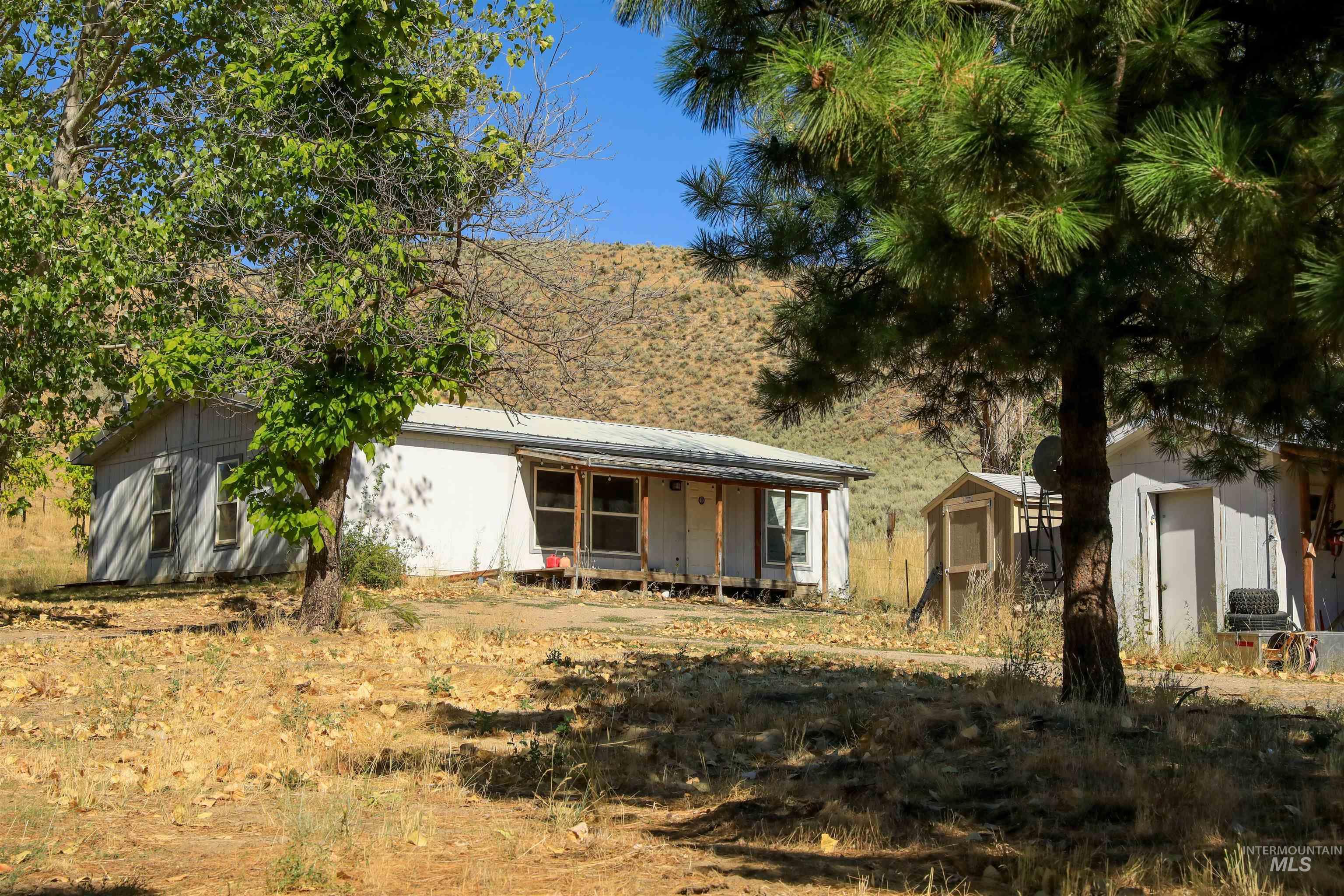 1550 Thousand Springs Road Weiser, ID 83672 - Photo 2 of 42 View of front of house with a storage shed, a porch, and a metal roof
