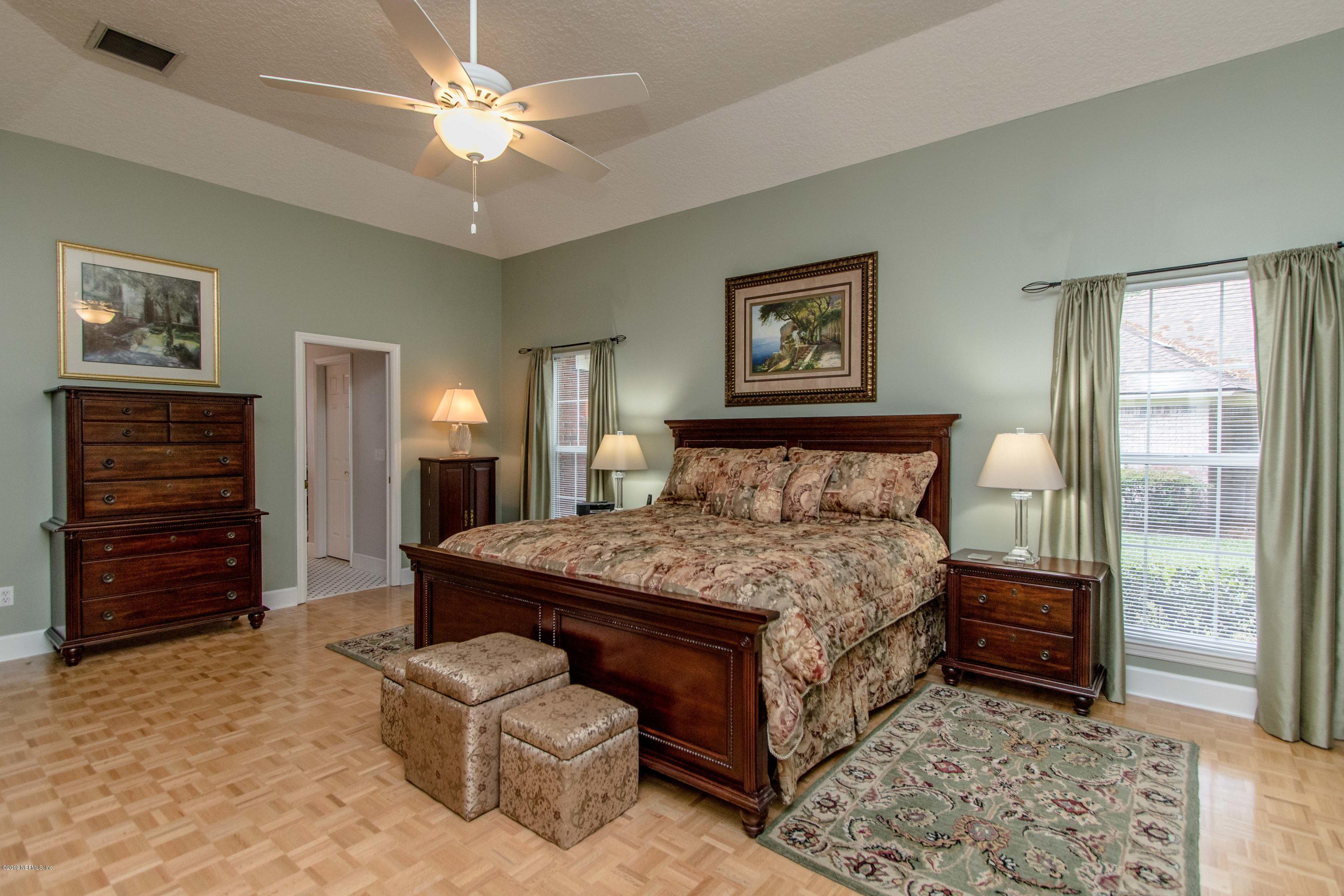 1944 Salt Myrtle Lane Fleming Island, FL 32003 - Photo 24 of 76 a bedroom with a bed and a chandelier