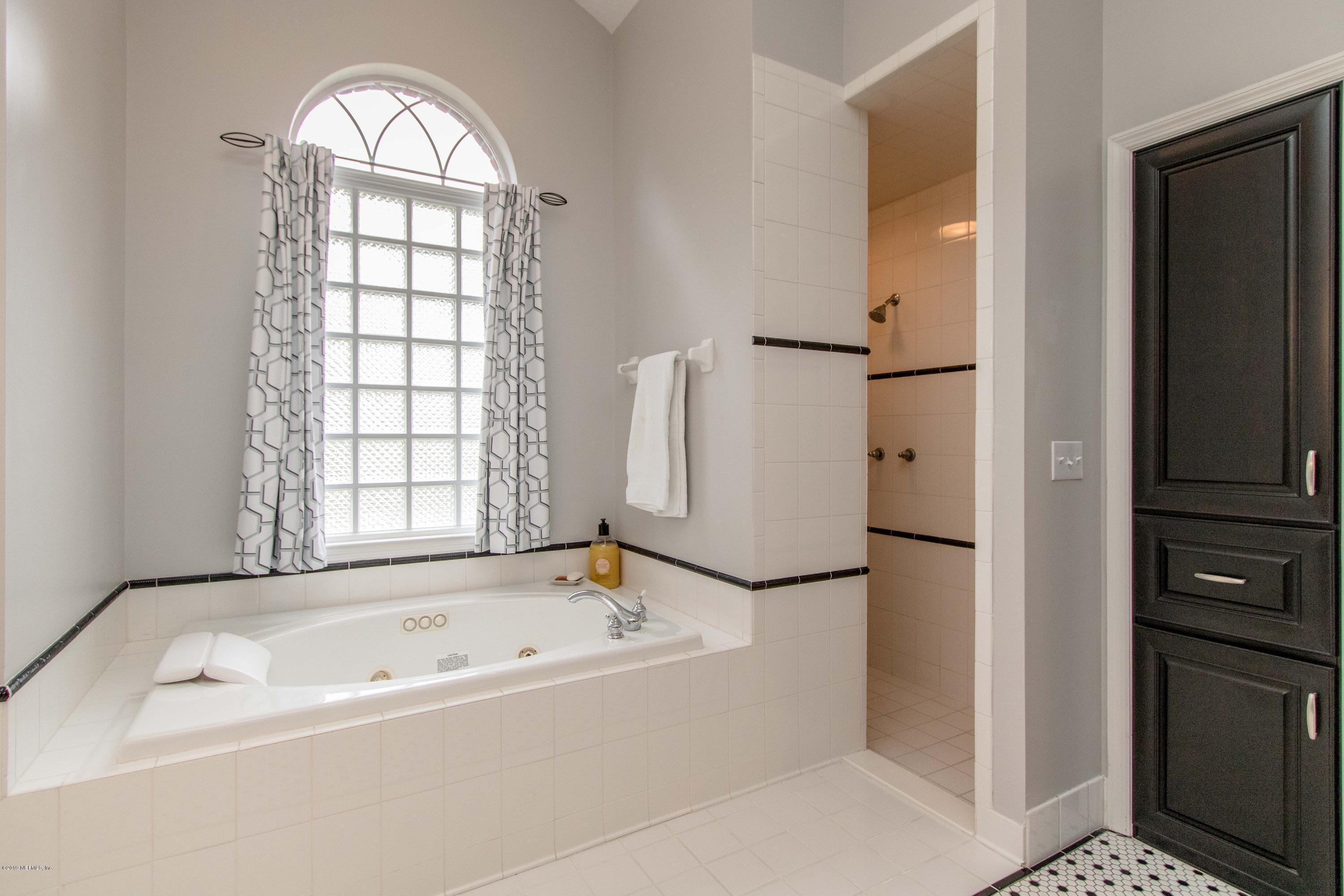 1944 Salt Myrtle Lane Fleming Island, FL 32003 - Photo 29 of 76 a bathroom with a bathtub and a shower