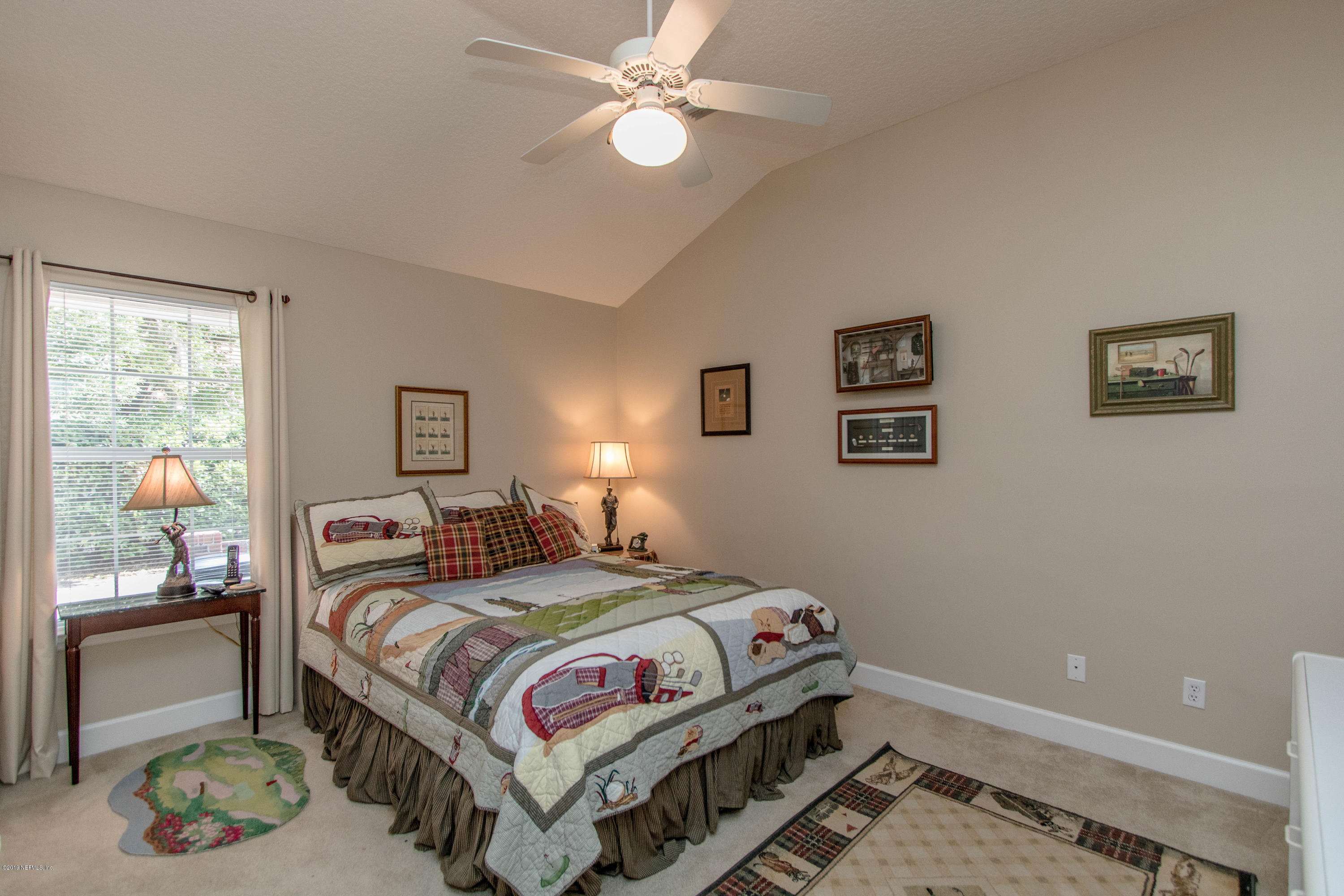 1944 Salt Myrtle Lane Fleming Island, FL 32003 - Photo 31 of 76 a bedroom with a bed and a lamp on dresser
