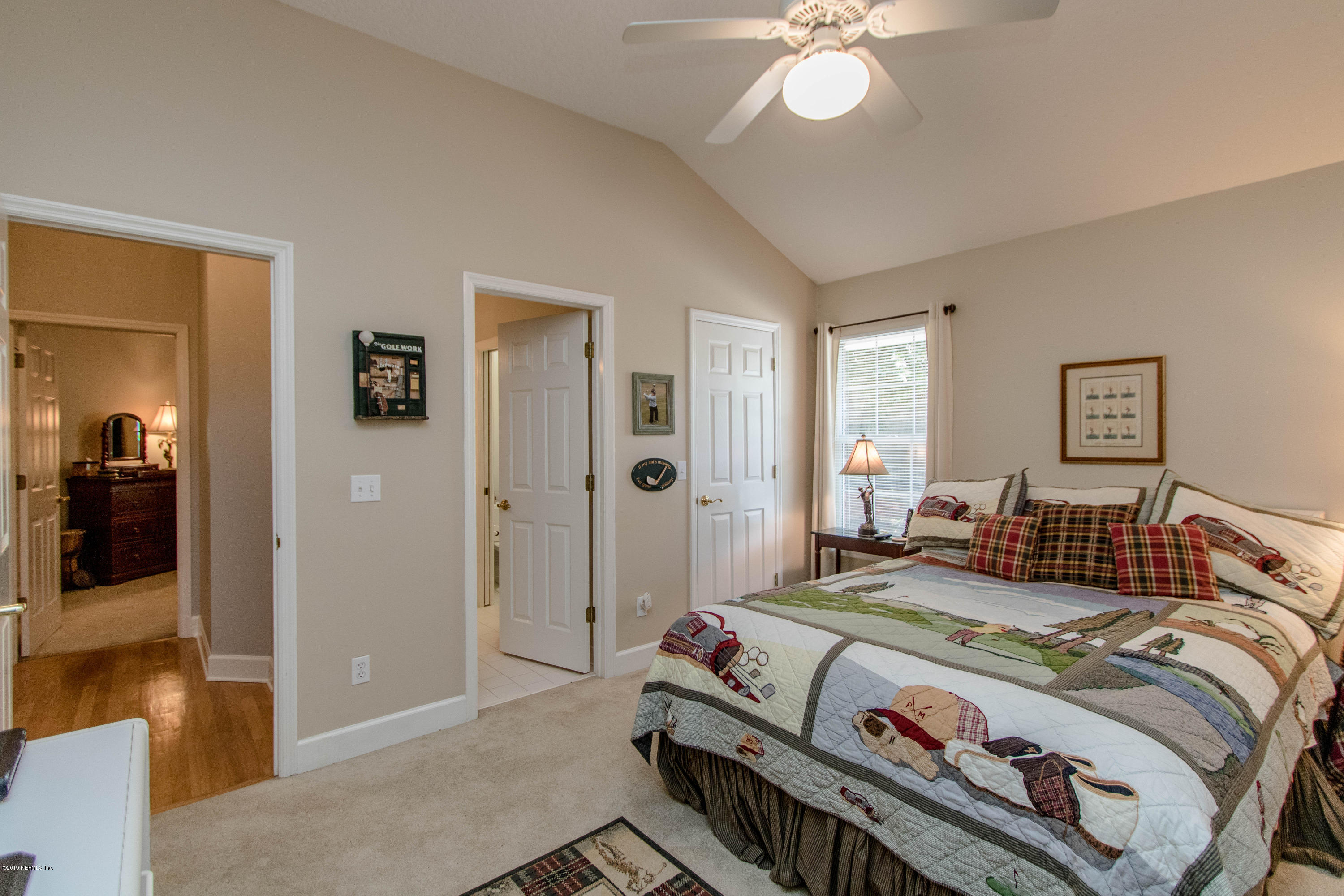 1944 Salt Myrtle Lane Fleming Island, FL 32003 - Photo 32 of 76 a bedroom with a bed and a chandelier