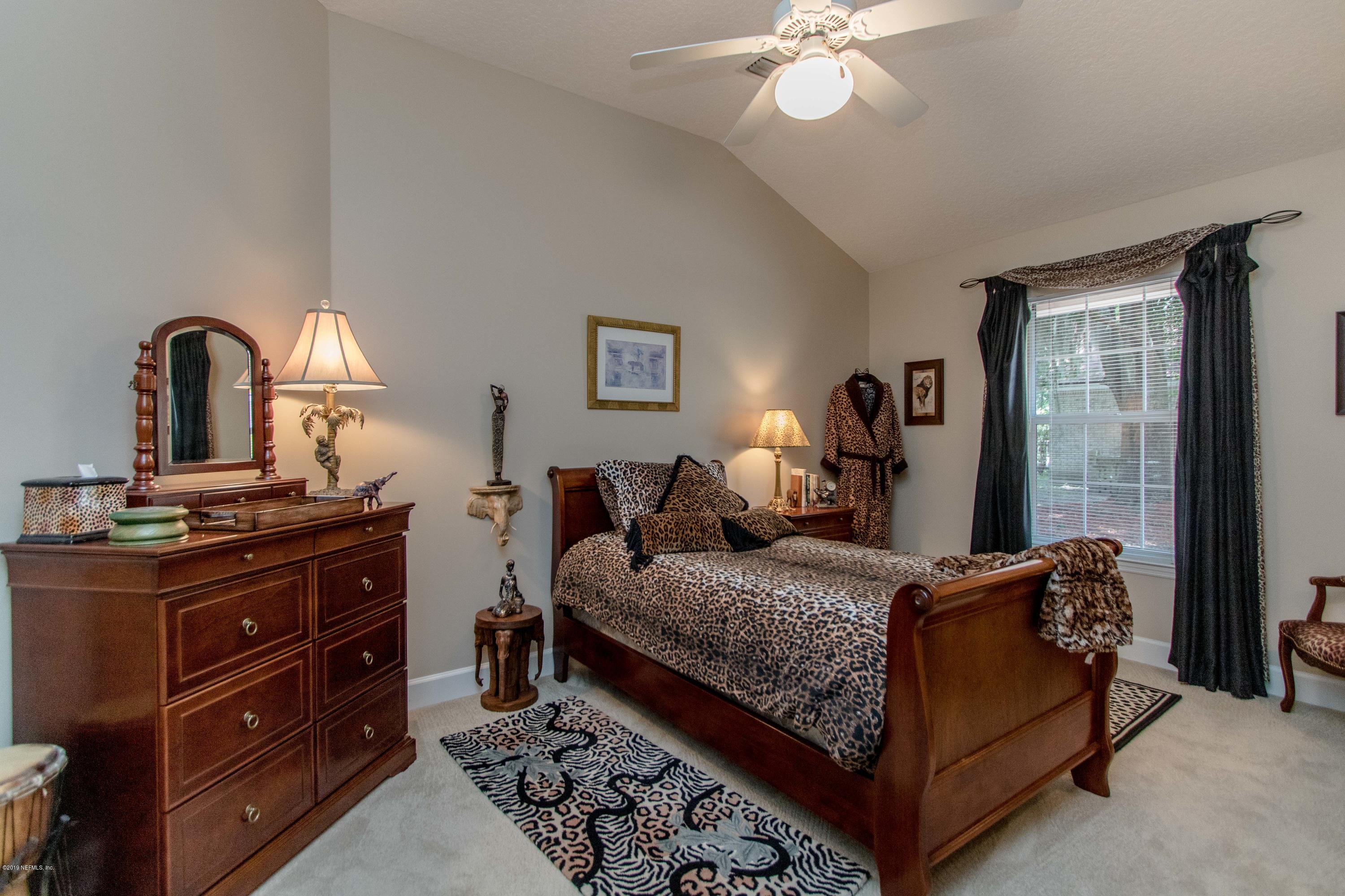 1944 Salt Myrtle Lane Fleming Island, FL 32003 - Photo 33 of 76 a bedroom with a bed and a chandelier