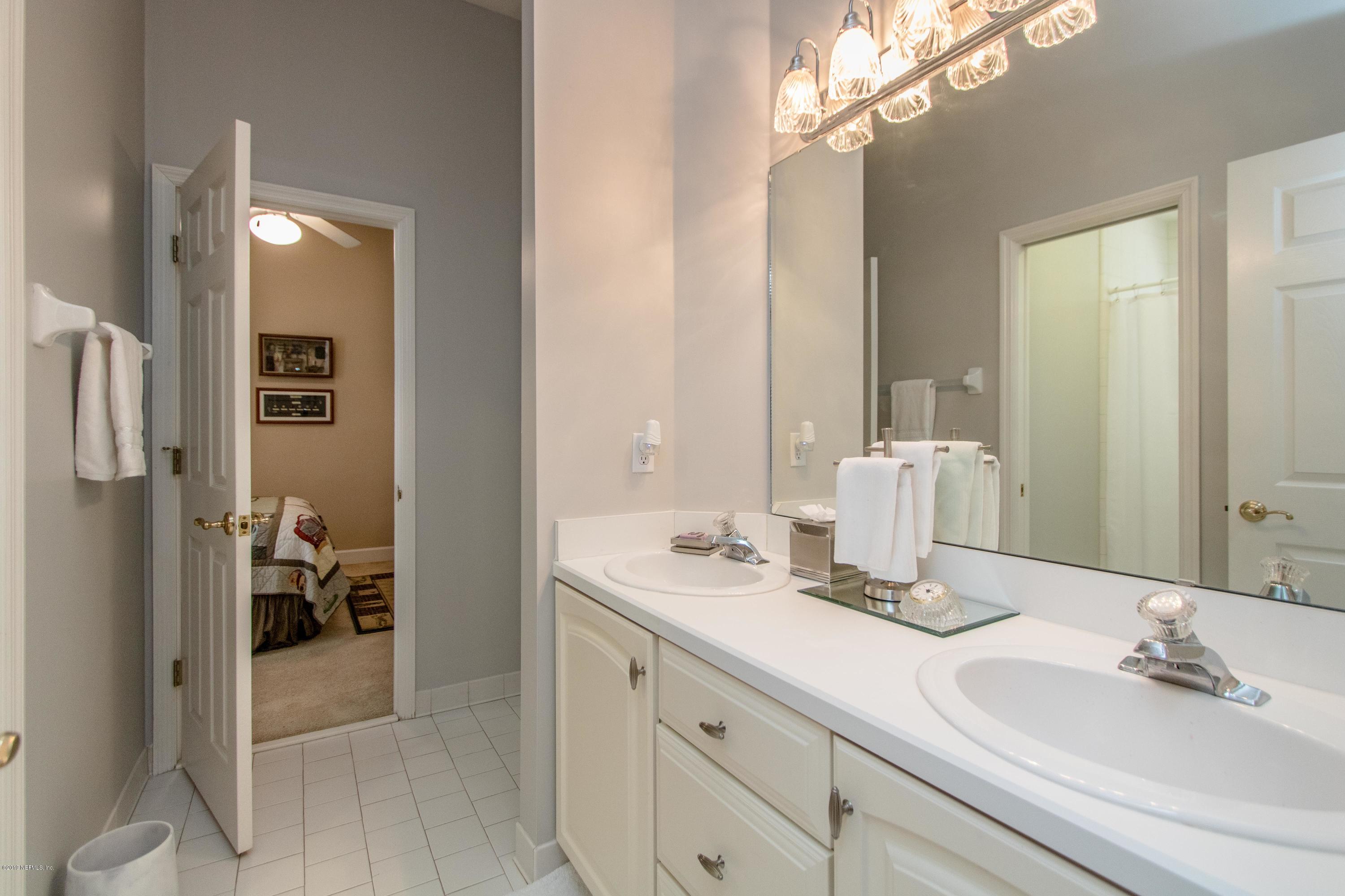 1944 Salt Myrtle Lane Fleming Island, FL 32003 - Photo 35 of 76 a bathroom with a double vanity sink and a mirror