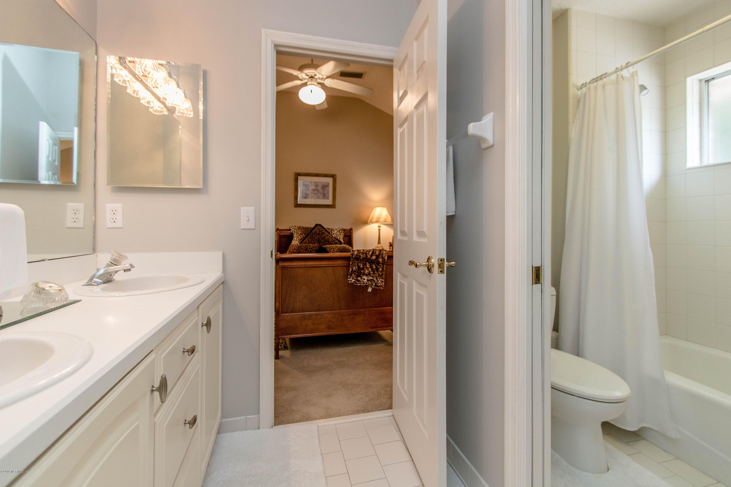 1944 Salt Myrtle Lane Fleming Island, FL 32003 - Photo 36 of 76 a bathroom with a sink a toilet and a mirror