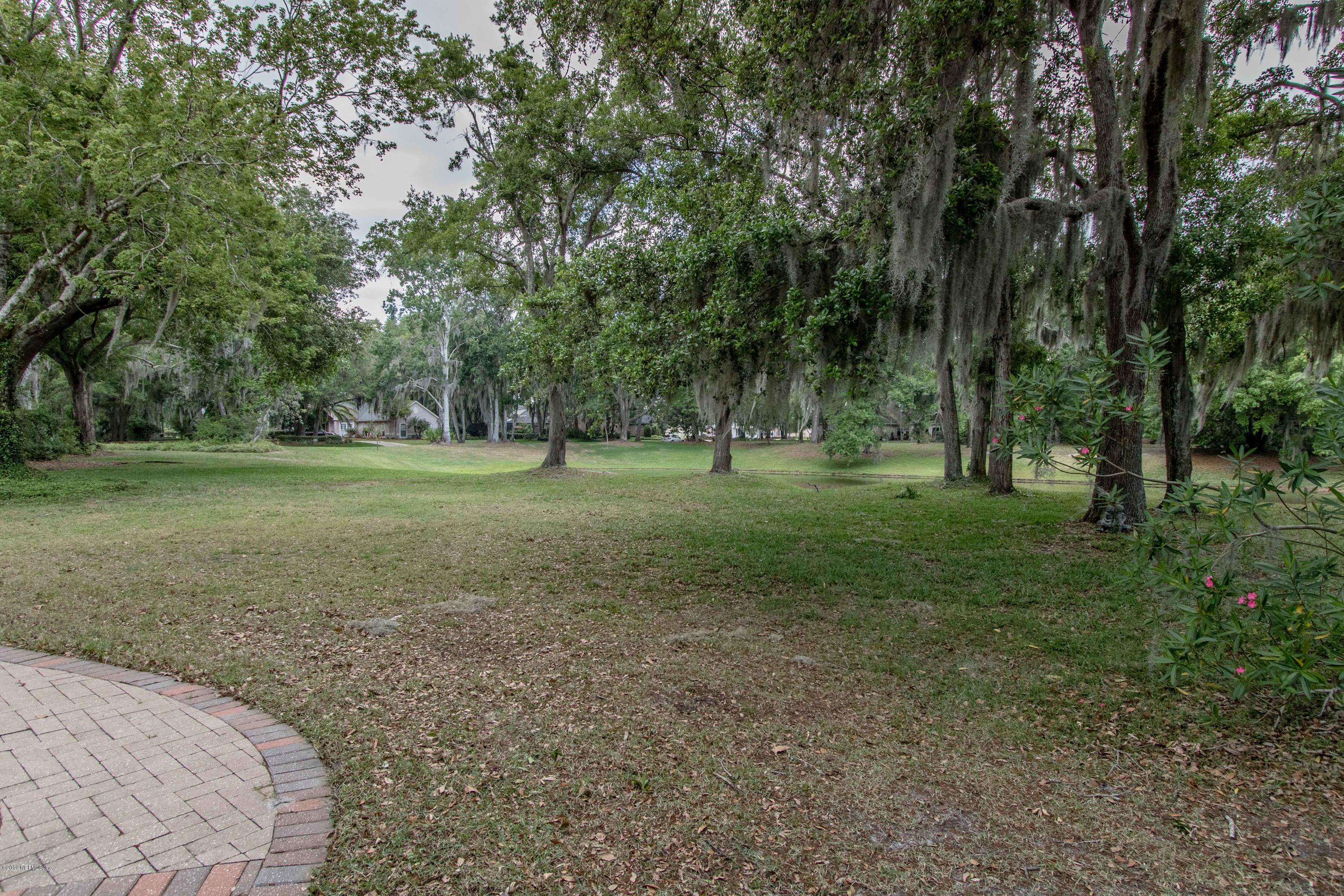 1944 Salt Myrtle Lane Fleming Island, FL 32003 - Photo 47 of 76 a view of a grassy field with trees