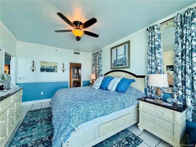 a view of a patio with a table and chairs under an umbrella with palm trees