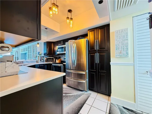 a kitchen with kitchen island granite countertop a sink stainless steel appliances and cabinets