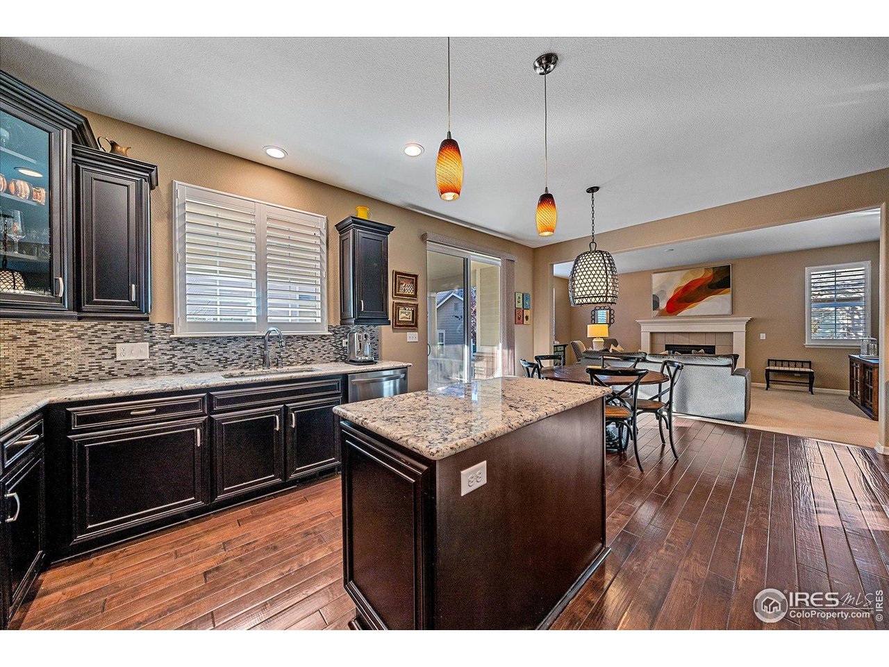4545 South Monaco Street, Unit 324 Denver, CO 80237 - Photo 13 of 36 a kitchen with stainless steel appliances granite countertop hardwood floor sink stove dining table and chairs