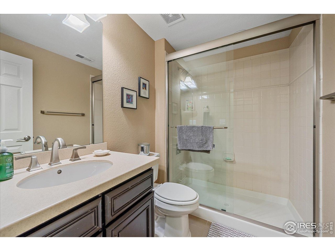 4545 South Monaco Street, Unit 324 Denver, CO 80237 - Photo 31 of 36 a bathroom with a sink a toilet a mirror and shower
