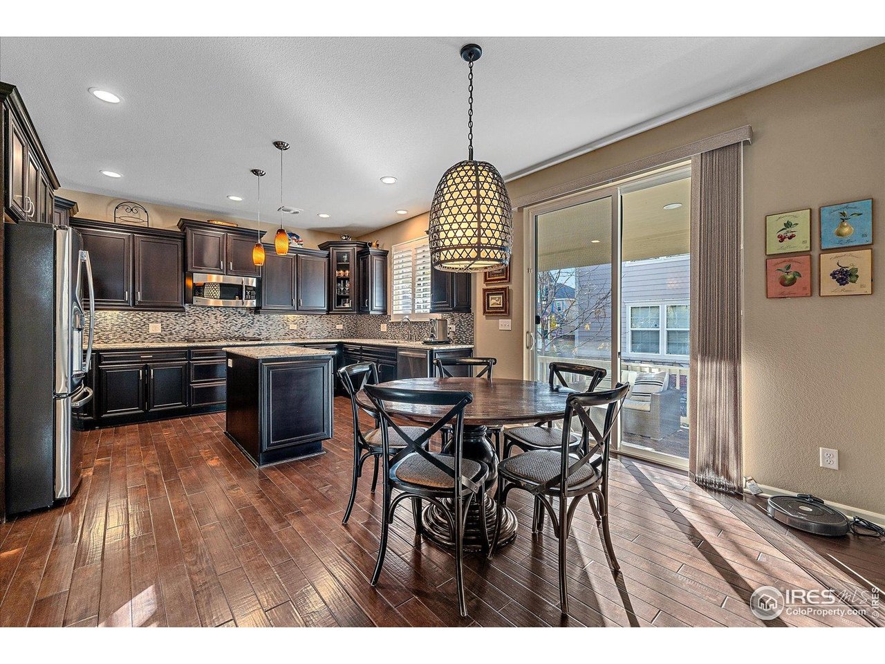 4545 South Monaco Street, Unit 324 Denver, CO 80237 - Photo 9 of 36 a open kitchen with stainless steel appliances granite countertop a stove top oven a sink dishwasher a dining table and chairs with wooden floor