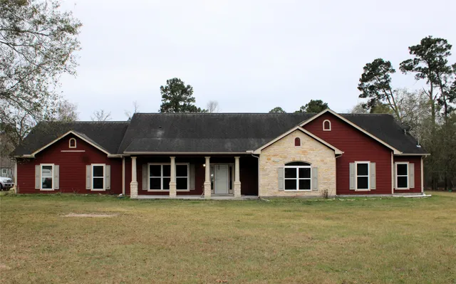 a view of a house with a big yard and large tree