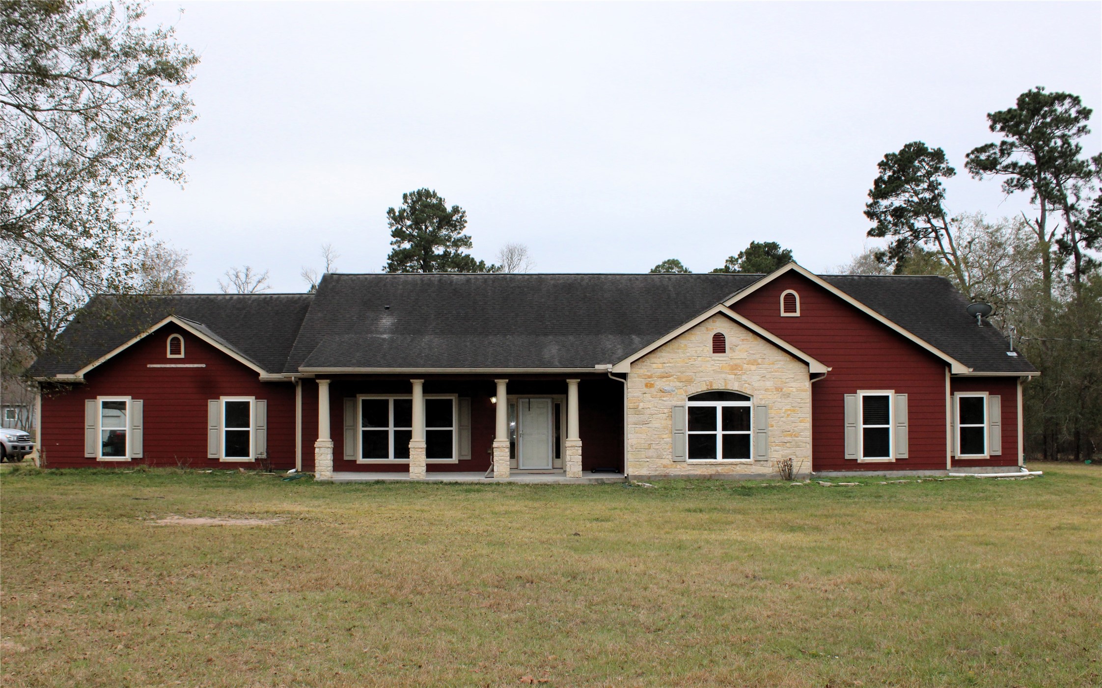 a view of a house with a big yard and large tree