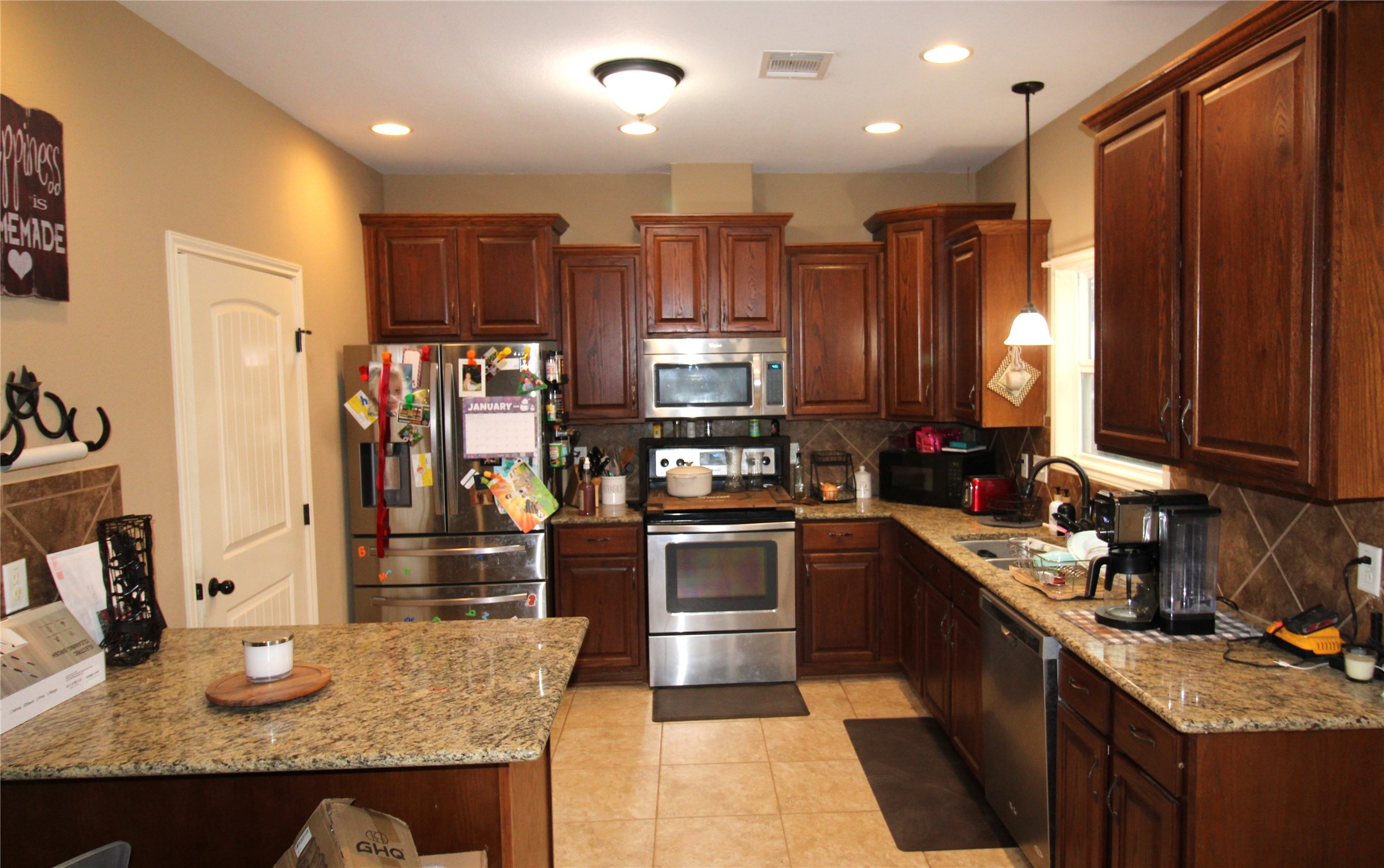14620 Lyric Road Conroe, TX 77302 - Photo 12 of 43 a kitchen with stainless steel appliances granite countertop sink stove refrigerator and cabinets