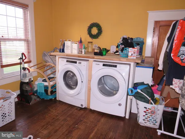 a utility room with wooden floor washer and dryer