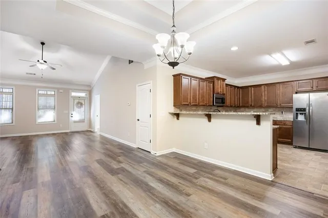 a view of a kitchen with a sink and dishwasher a refrigerator with wooden floor