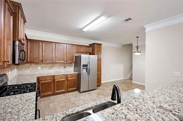 a kitchen with granite countertop a refrigerator and a sink