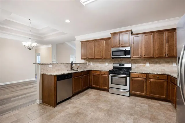 a kitchen with stainless steel appliances granite countertop wooden cabinets a stove a sink and dishwasher