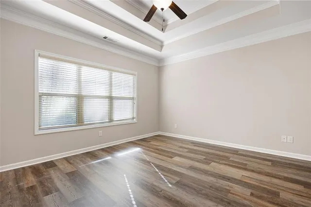 an empty room with a window and ceiling fan