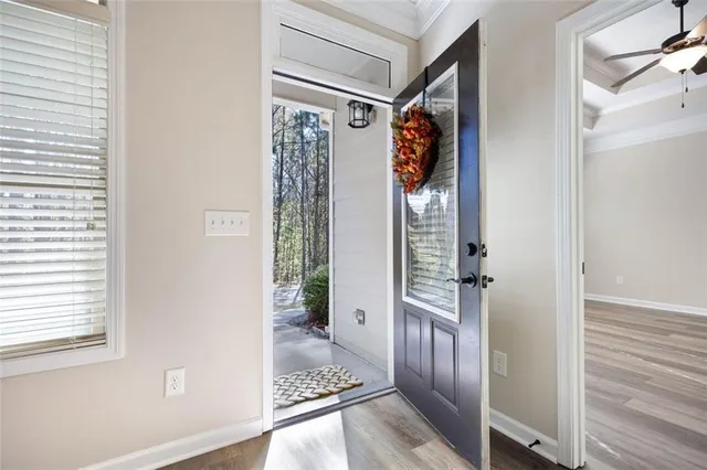 a view of a hallway with wooden floor and windows
