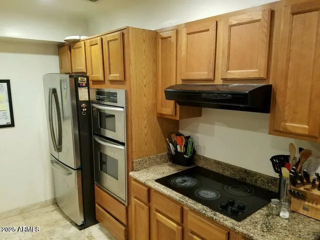 a kitchen with stainless steel appliances granite countertop a sink stove and refrigerator