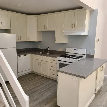 a kitchen with granite countertop a sink a stove and cabinets