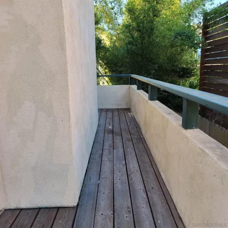 a view of balcony with wooden floor and fence