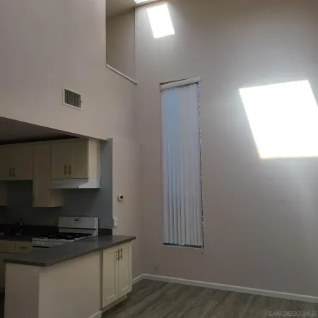 a kitchen with granite countertop a sink a stove and cabinets