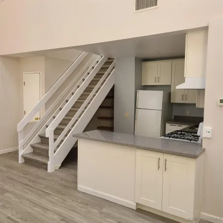a kitchen with cabinets and wooden floor