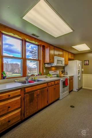 4670 Rich Road DeKalb, IL 60115 - Photo 5 of 24 a open kitchen with stainless steel appliances granite countertop a sink window and cabinets