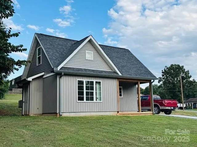 a view of a house with a yard and sitting area