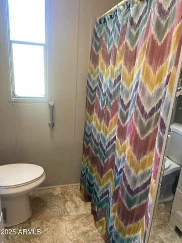 a white toilet sitting next to a shower