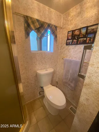 a white toilet sitting next to a shower