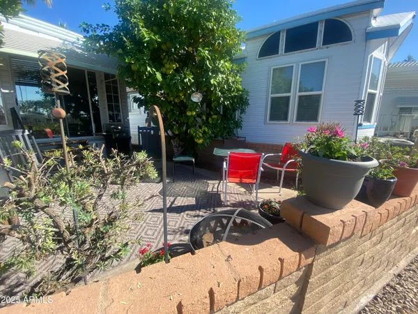 a view of a chair and tables in the back yard of the house