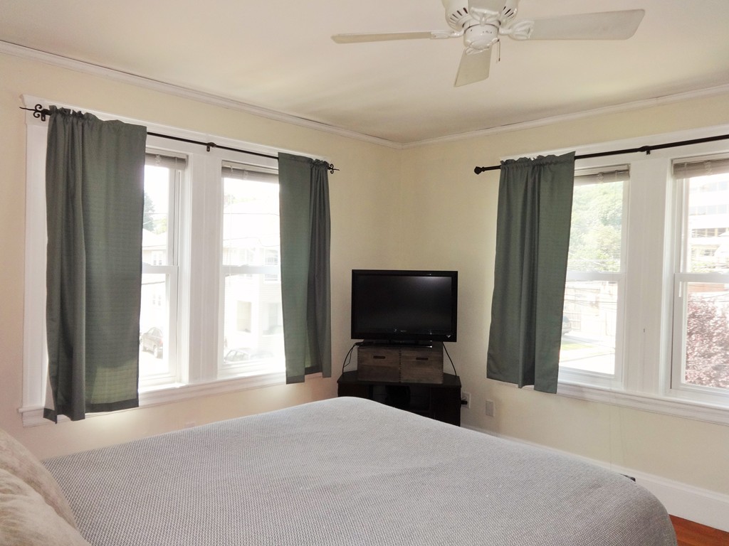 37 Everett Street, Unit 3 Waltham, MA 02453 - Photo 7 of 16 a bedroom with a bed and a flat screen tv