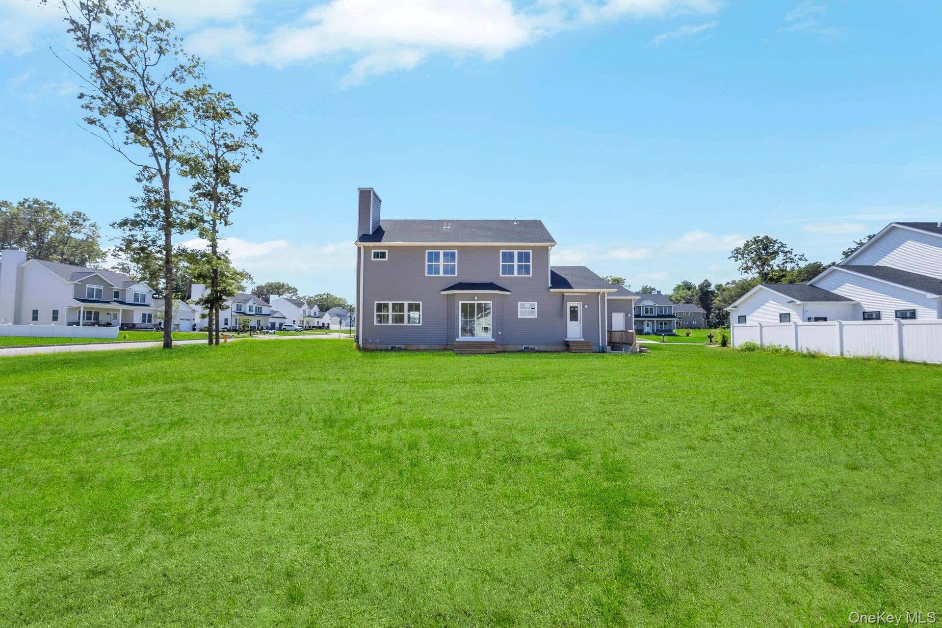 Lot #4 Cardinal Court Ridge, NY 11961 - Photo 15 of 48 a view of a house with a big yard and large trees