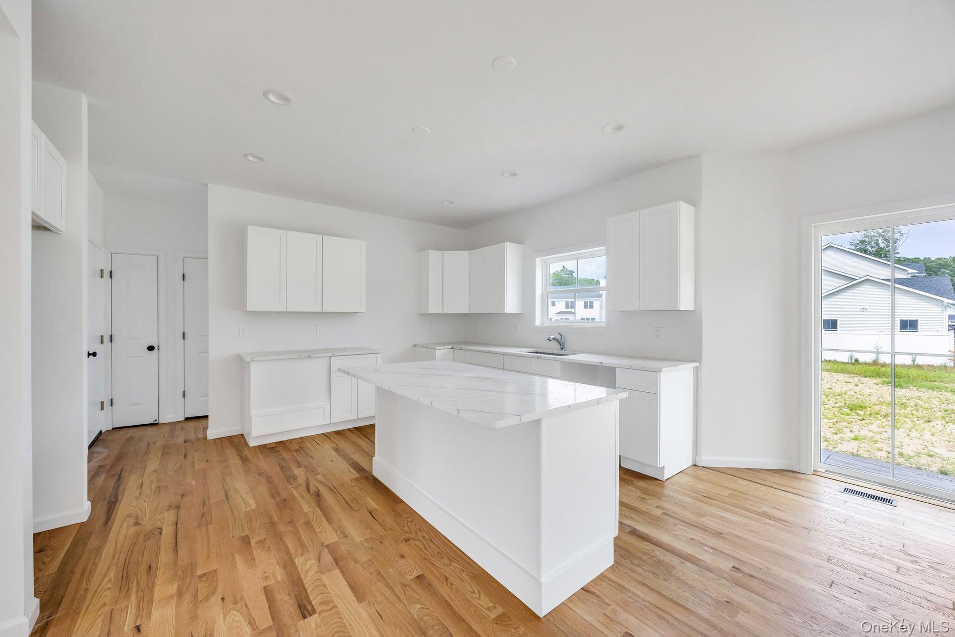 Lot #4 Cardinal Court Ridge, NY 11961 - Photo 25 of 48 a kitchen with wooden floors and white walls