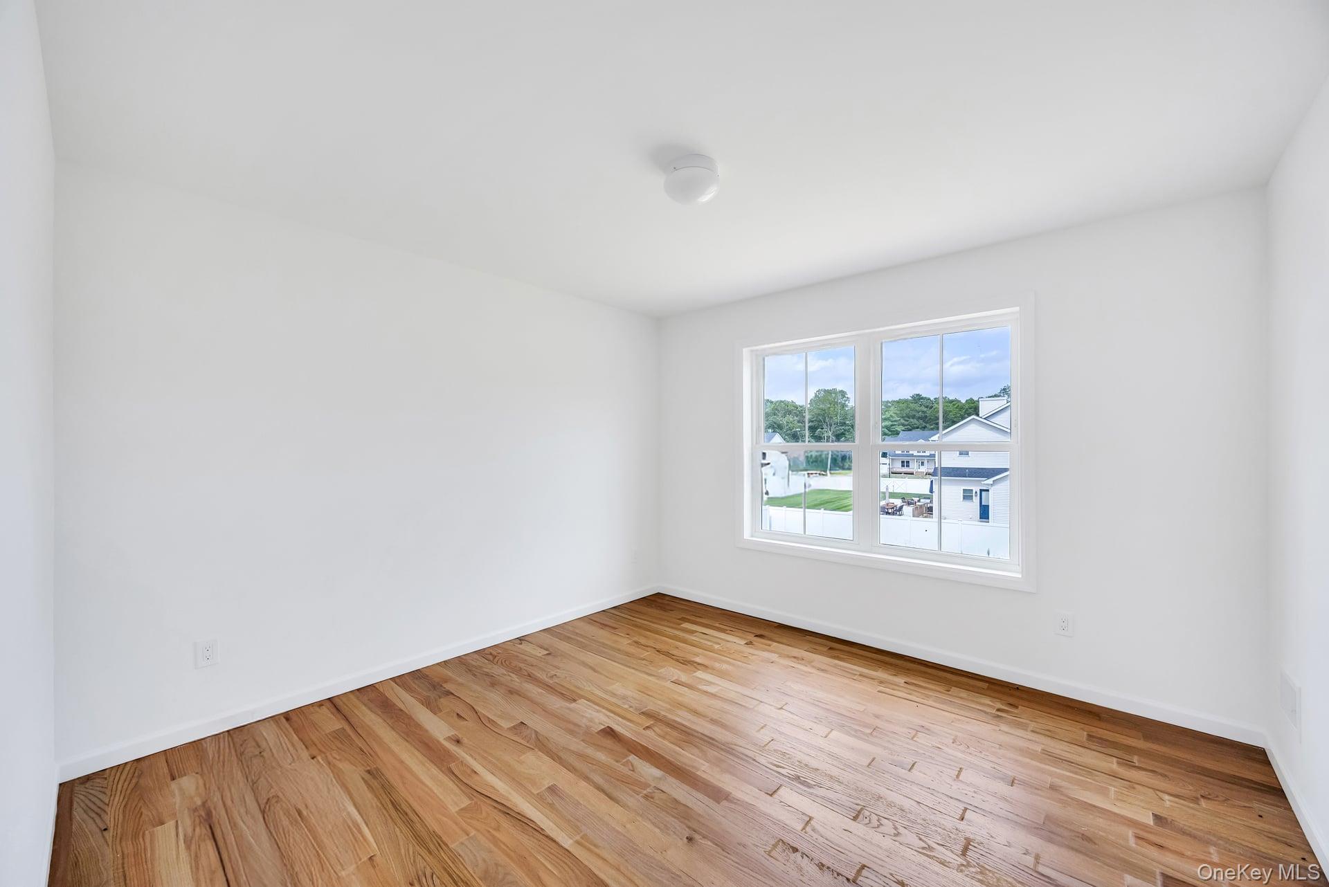 Lot #4 Cardinal Court Ridge, NY 11961 - Photo 32 of 48 an empty room with wooden floor and windows