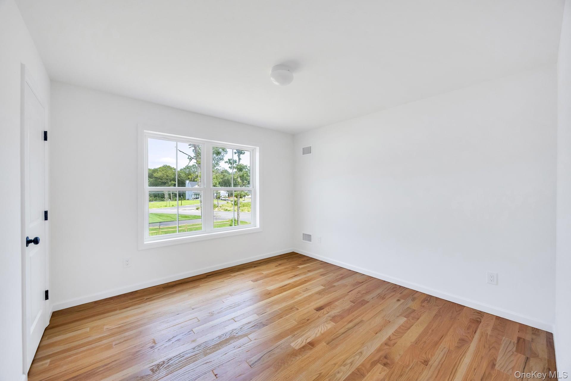 Lot #4 Cardinal Court Ridge, NY 11961 - Photo 38 of 48 a view of an empty room with wooden floor and a window