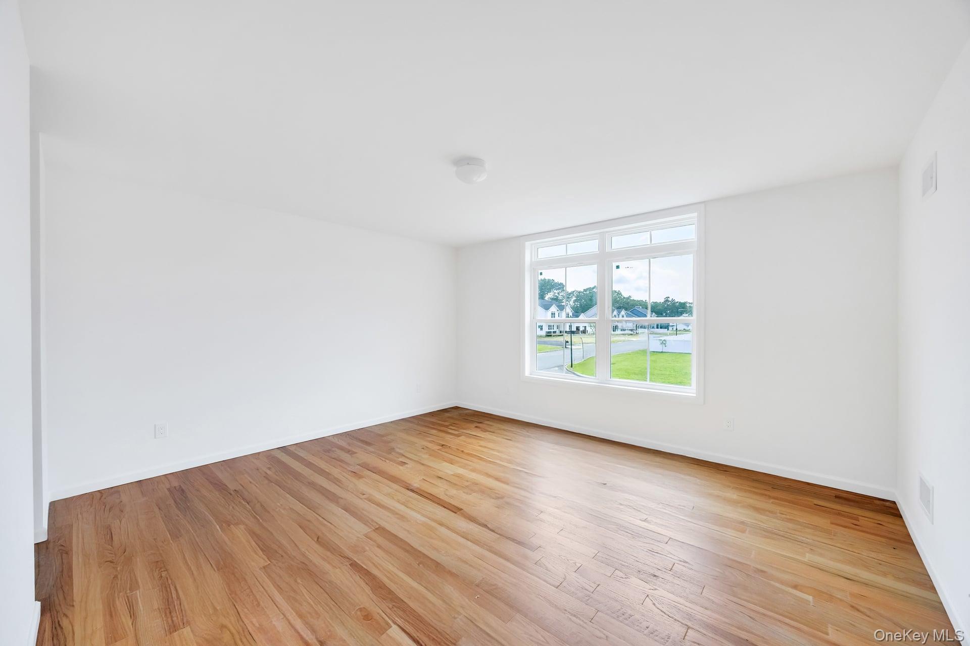 Lot #4 Cardinal Court Ridge, NY 11961 - Photo 40 of 48 an empty room with wooden floor and windows