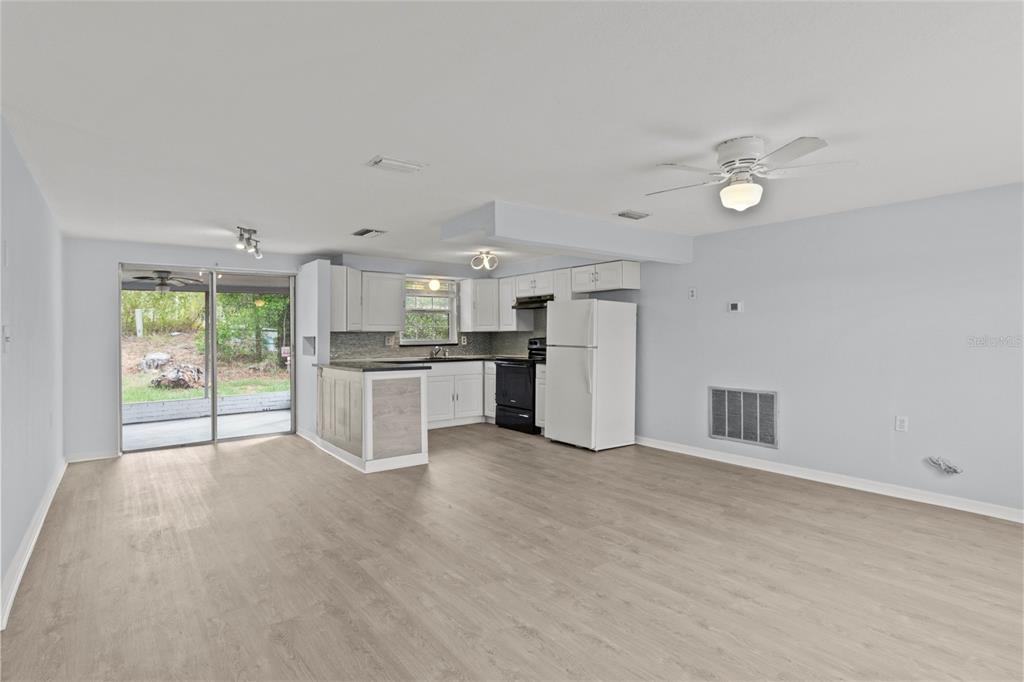 1623 Plum Tree Road Holiday, FL 34690 - Photo 4 of 33 a view of a kitchen with wooden floor and a ceiling fan