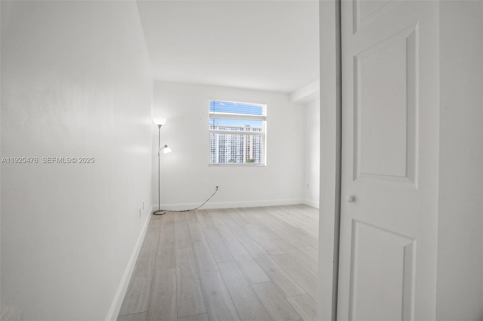 17150 North Bay Road, Unit 2706 Sunny Isles Beach, FL 33160 - Photo 23 of 47 an empty room with wooden floor and window