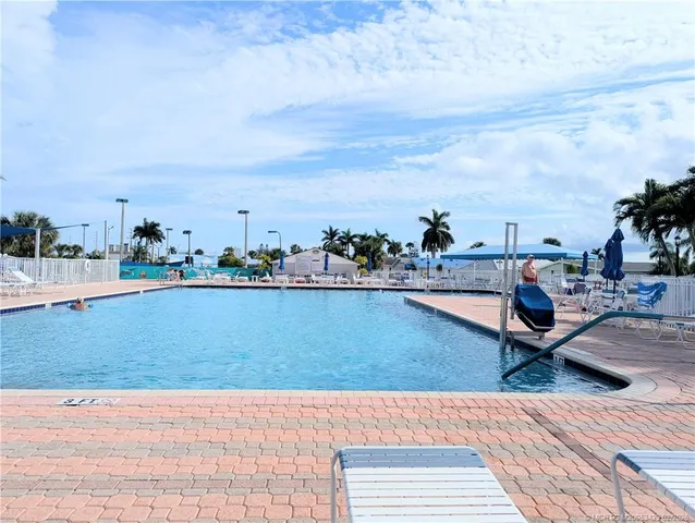 a view of swimming pool with outdoor seating and city in the back