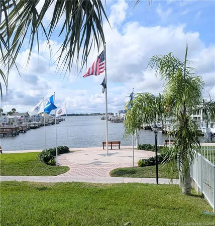 front view of house with a yard and palm trees
