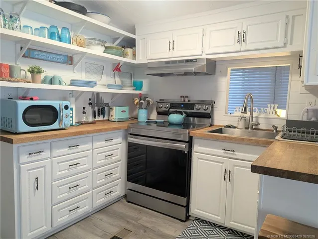 a kitchen with granite countertop white cabinets and stainless steel appliances