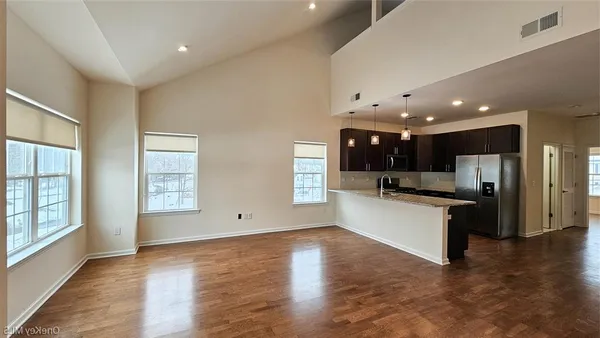 a large kitchen with stainless steel appliances kitchen island a large counter top and a wooden floors