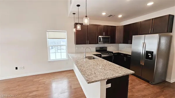 a kitchen with kitchen island a counter top space cabinets and stainless steel appliances