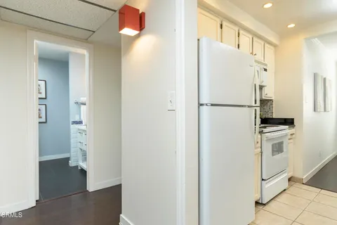 a white refrigerator freezer and a stove sitting inside of a kitchen